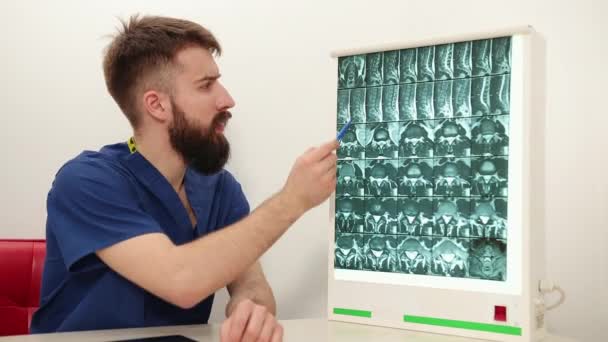 O fisioterapeuta mostra ao paciente uma imagem radiológica do esqueleto dos ossos. Consulta — Vídeo de Stock