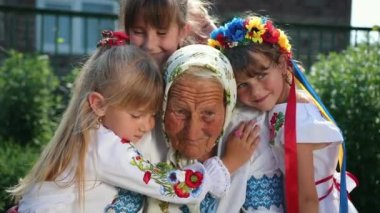 Yaşlı bir büyükanne sokakta oturuyor ve bir kitap okuyor. Vyshyvanka.