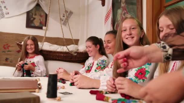 Skupina dívek vyrábí šperky z šálů, ručně vyráběných, jehličnatých kruhů. — Stock video