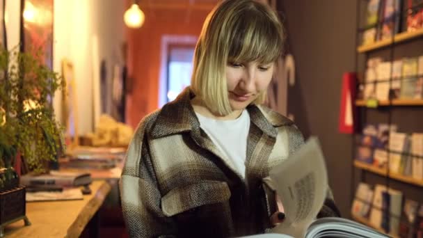 Žena, která čte v knihovně. Portrétní vysokoškolačka listuje stránkami. Ženská kniha — Stock video