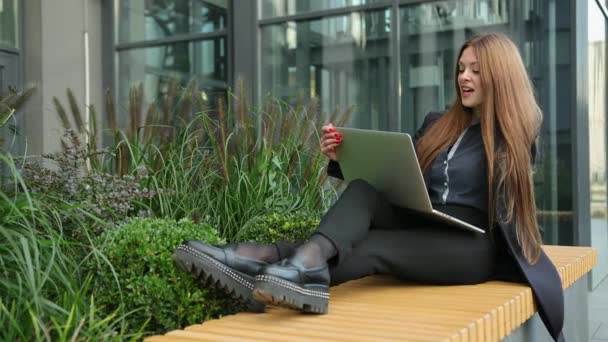 Vrouwelijke voeten op houten bank met laptop. Freelance, werken op afstand buiten. — Stockvideo