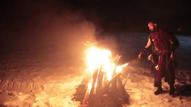 Viking avec une torche allume le feu de joie. Brutal mâle d'apparence dangereuse feu. — Video