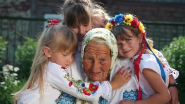 Yaşlı bir büyükanne sokakta oturuyor ve bir kitap okuyor. Vyshyvanka.