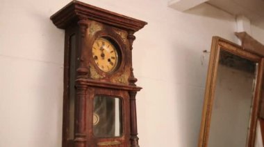 Bir zamanlar odada saati gösteren kırık antika mekanik duvar saati. Süre