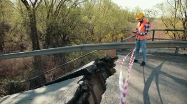 Düşen parçalar, montajlar, tehlike. Eski bir köprüdeki hasarlı yollar. Kırık yol