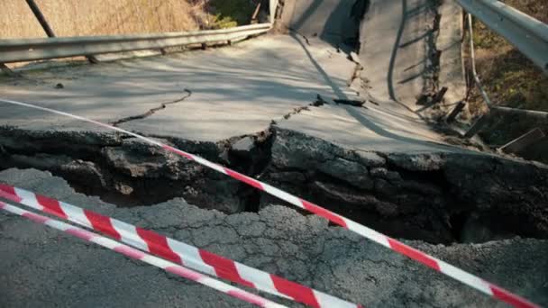 Потоп повредил закрытую дорогу, мост. Разбитый асфальт после землетрясения. — стоковое видео
