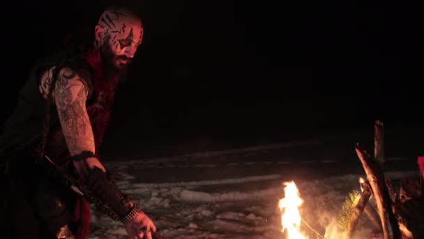 Vikingo con una antorcha enciende la hoguera. Brutal guerrero masculino de apariencia peligrosa por el fuego. — Vídeos de Stock