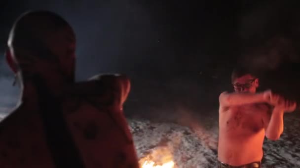Combate al malvado guerrero vikingo agresivo en los tatuajes del norte quemando espadas de fuego — Vídeo de stock