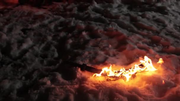 Το φλεγόμενο σπαθί βρίσκεται στο χιόνι μετά το τέλος της μάχης. Χειμερινή νύχτα χαμηλό φως — Αρχείο Βίντεο