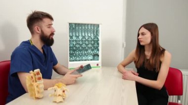 Kadın hasta klinikte erkek terapistle konuşuyor. Fizyoterapist hastalandı.