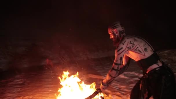 Evil aggressive viking warrior in northern tattoos bare torso sets fire swords — Stock Video