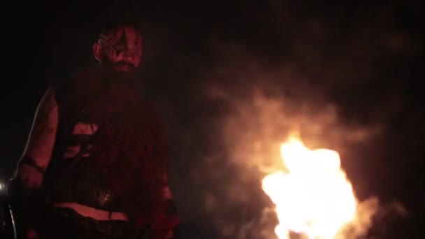 Вікінг з факелом запалює багаття. Жорстокий чоловік воїн небезпечної зовнішності біля вогню . — стокове відео