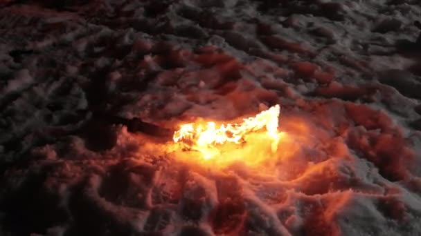 La espada ardiente yace en la nieve después de que la batalla haya terminado. Noche de invierno con poca luz — Vídeo de stock