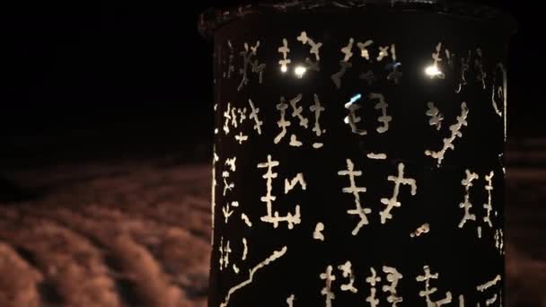Черная бочка, которая светится древними символами руны викингов на зимнем снегу — стоковое видео