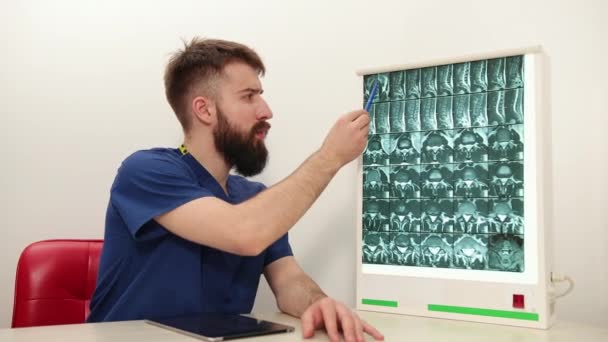 A fizioterapeuta egy csontváz röntgenképét mutatja a betegnek. Konzultáció — Stock videók