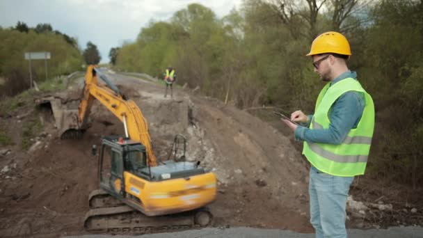 Ingénieur travaillant sur la construction routière, poutre en acier, âme installée sur le pont — Video