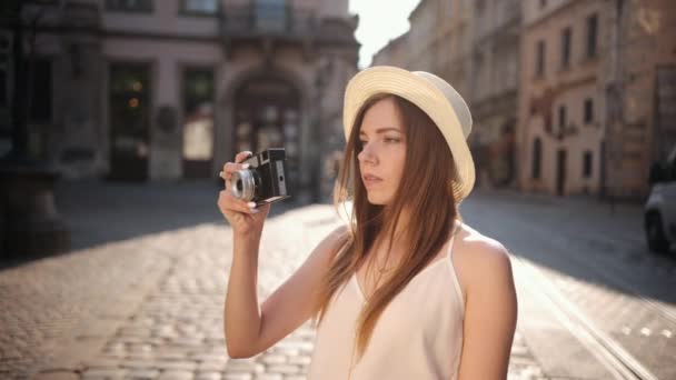 Fotograf podróżny robi zdjęcia w hipsterskim kapeluszu. Turystka podróżująca — Wideo stockowe