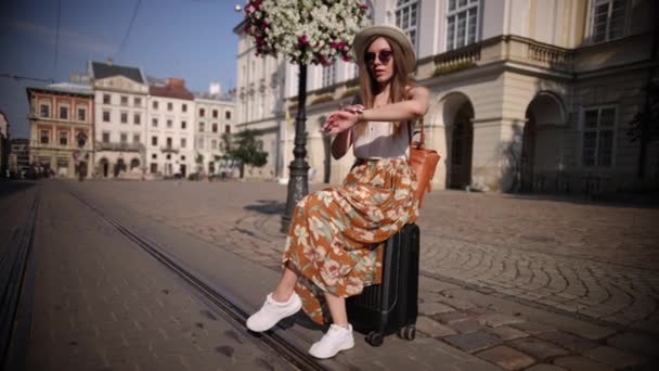 Cestovatelka sedící na kufru a snila o dobrodružstvích. Koncept cestování. — Stock video