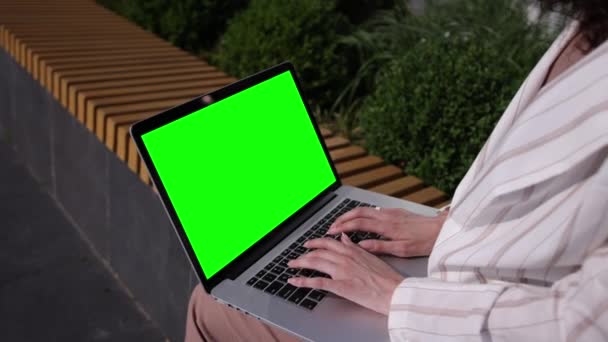 Φορητός υπολογιστής σε γύρους γυναικών σε εξωτερικούς χώρους. Άποψη από πίσω της γυναίκας στα λευκά — Αρχείο Βίντεο