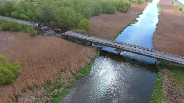 Bruten bro, krypskytt grävmaskin vid floder trasiga väg struktur förstörd väg — Stockvideo