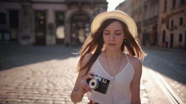 Touriste explore la vieille ville. Sourire, faire des photos sur un appareil photo rétro. Extérieur — Video