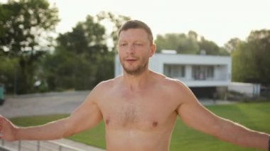 Genç güçlü kaslı üstsüz beyaz erkek sporcu burpee egzersizi yapıyor.
