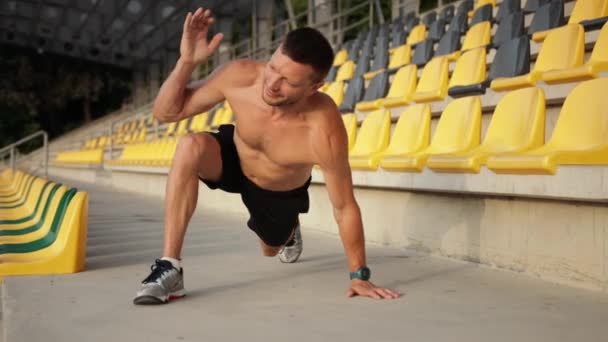 Hombre en forma ejercitando la mano exterior al aire libre. Guapo deportista haciendo estiramiento — Vídeo de stock