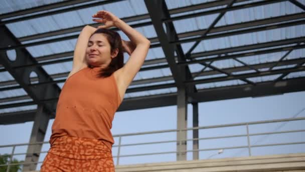 De vrouw die zich buiten uitstrekt. jonge Kaukasische atletische vrouw doet een warming-up — Stockvideo