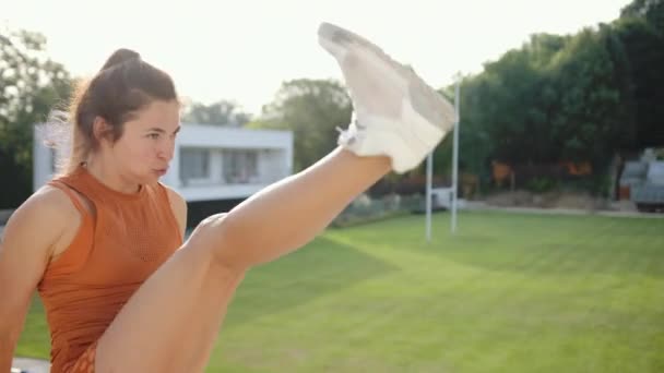 Exercício de atleta feminina confiante, chutes de perna de prática, chutando ar em sportswear — Vídeo de Stock