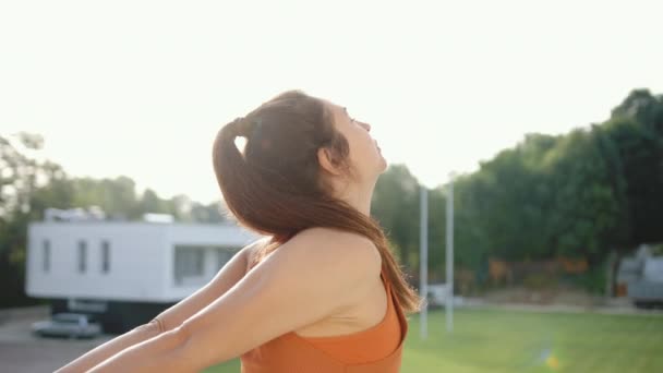 Junge, attraktive Frau macht vor dem Outdoor-Training ein paar Schulterstrecken. — Stockvideo