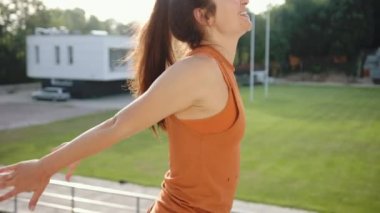 Açık havada esneyen bir kadın. Vücudunun ısınmasını sağlıyor. Kendinden emin.