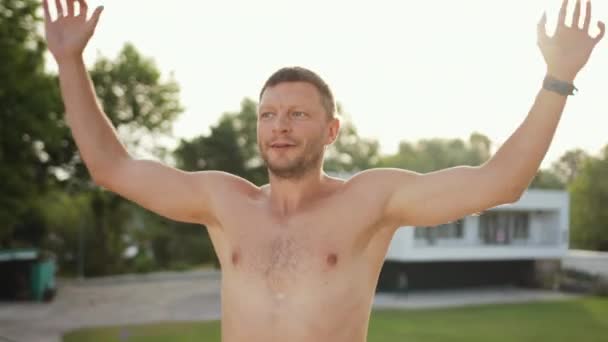 Ung idrottsman, övningar. Träning ensam utomhus. Upp med händerna, hoppa. — Stockvideo
