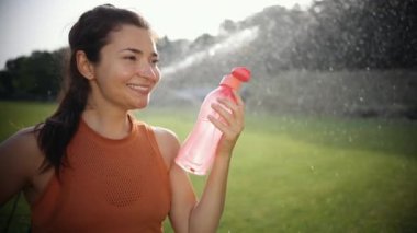 Kadın şişeyi tutuyor fitness eğitiminden sonra temiz su içiyor.