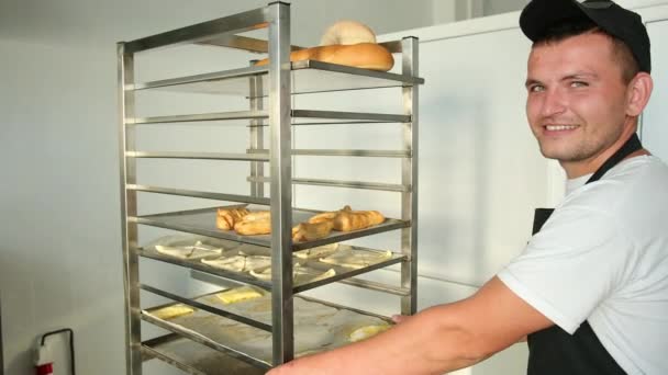 Horno de llenado Baker en panadería, panadería. El hombre mueve la bandeja con panes frescos — Vídeos de Stock