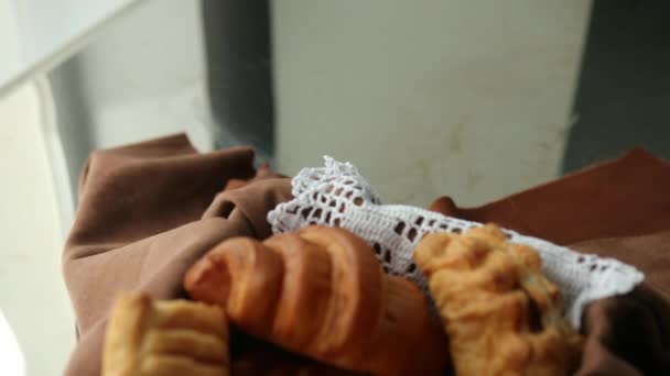 Galletas caseras y bollos en canasta de pan sobre un fondo marrón. Estilo de vida — Vídeos de Stock