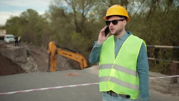 Portret młodego mężczyzny rozmawiającego przez telefon. Mężczyzna architekt, telefon komórkowy — Wideo stockowe