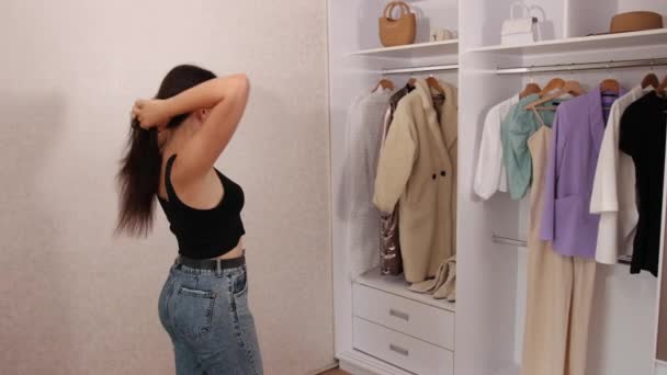 Mujer guapa y segura eligiendo chaqueta en una tienda de trajes, mujer joven — Vídeos de Stock