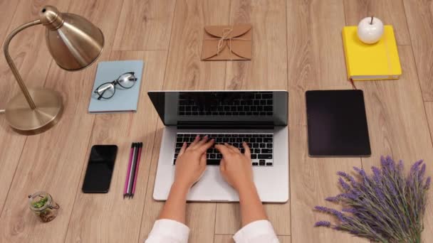 Spazio di lavoro con computer portatile, mani di ragazze, notebook su sfondo di legno. Posa piatta — Video Stock