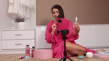 Blog yazarı akıllı telefon kamerasında kozmetik video bloğunu açarken çekiyor. Kadın vlogger