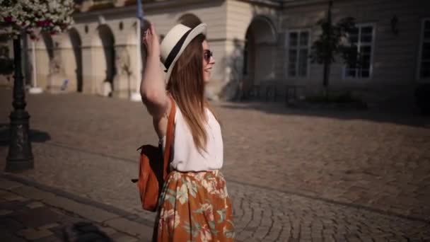 Une fille portant des lunettes de soleil avec une valise rentre chez elle après le voyage. Jeune femme — Video