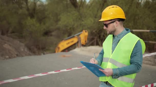 Dělník, inspektor, inženýr kontroluje povrch silnice po hurikánu. Kontrolovat — Stock video
