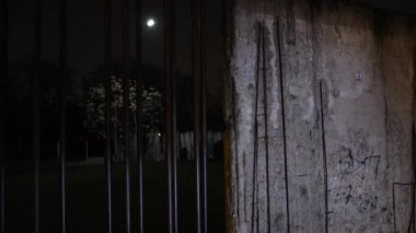 Duvar yolu, Berlin Duvarı Anıt Merkezi, Berlin Duvarı. Berlin Duvarı Anıtı loş sokak lambalarıyla hafifçe aydınlatılıyor. Huzurlu bir gece manzarası yolu ve çevresi yaratıyor..