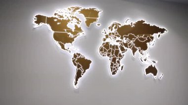 Dünya haritası, parlayan duvar, sanatsal harita. Modern duvar montajlı dünya haritası metalik panellerden yapılmış, ışıldayan LED arka ışıklandırma, şık ofis veya seyahat temalı dekor için kullanılır.