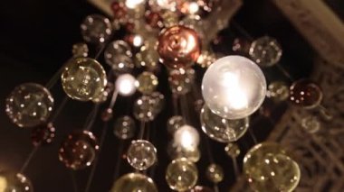 Şenlikli dekor, Noel yaratımı, şenlikli heykel. Klasik bina sergilerinin merkez avlusu cam süsler ve altın ışıklardan yapılmış parlayan Noel ağacı.