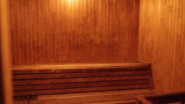 Kuru sauna, sağlık terapisi, sıcak aydınlatma. Geleneksel kuru sauna odası ahşap, bank oturma ve yumuşak kehribar aydınlatma, rahatlama ve ısı terapisi için hazır.