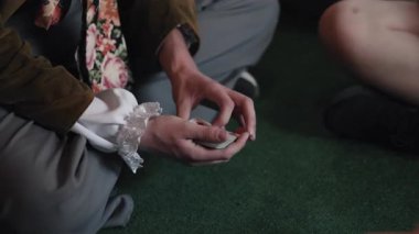 Sihirbaz gösterisi, kart numarası, sihir gösterisi. Tiyatro kostümlü sihirbaz, yerde otururken kart numarası yapar. Hünerli el ve eğlence becerileri sergiler..