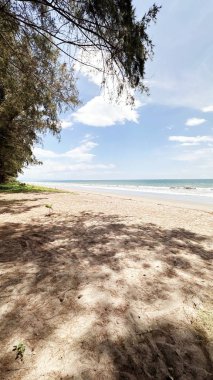 Uzun kıyı şeridi el değmemiş gibi görünen krem rengi kumla uzanıyor. Deniz suyu, küçük dalgaların kıyıya vurduğu, yumuşak beyaz bir köpük oluşturan turkuaz mavisi bir turkuazdır..