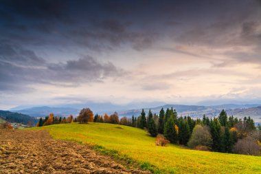 Sonbaharda dramatik bulutlar ve yumuşak akşam ışığı ile yakalanan Litwina 'nın yuvarlanan tepeler, ormanlar ve uzak Tatra Dağları üzerindeki geniş görüşü