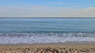 Akdeniz 'in Barselona manzarası yumuşak dalgalarla kumlu kıyıya vuruyor.