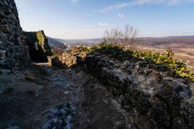 Nevytske Kalesi 'nin yıpranmış taş duvarları ve patikası, ötesine uzanan geniş bir manzarayla tarihe bir bakış sunuyor.